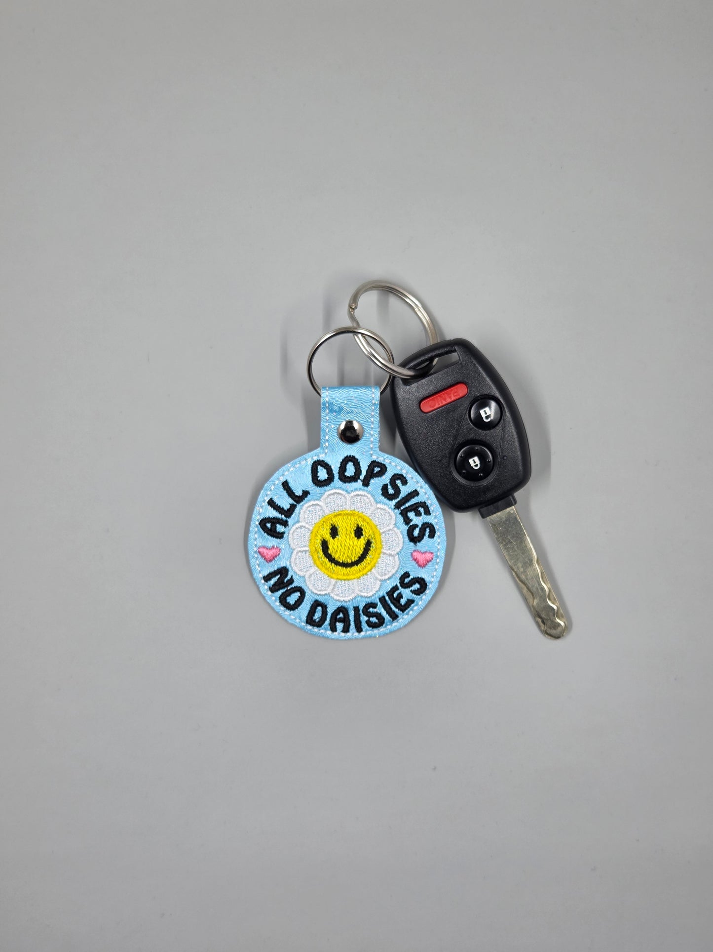 “All Oopsies No Daisies” Embroidered Keychain | Vinyl Smiley Flower Keychain